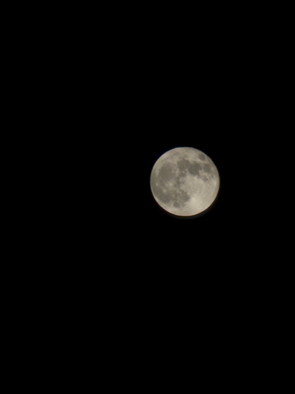 A close-up shot of the moon taken at night, featuring clear details of its surface against a dark sky.