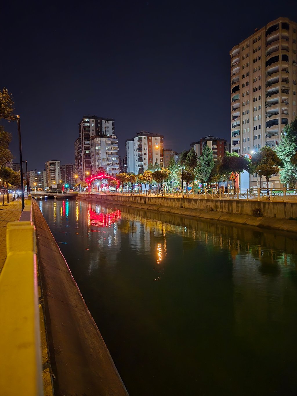 Gece çekimi sırasında şehrin binaları ve su kanalı, aydınlatmalarla renklendirilmiş.