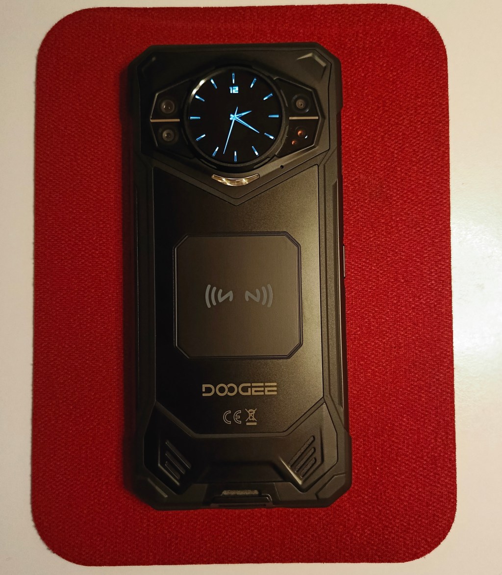 Kırmızı bir yüzeyin üzerinde duran DOOGEE marka cep telefonu.